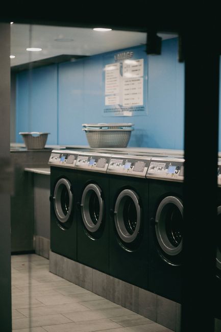 Front loading washing machines lined up in a laundry